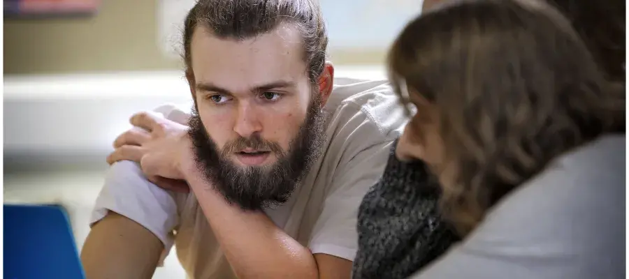 A group of students look at a screen whilst contemplating a question