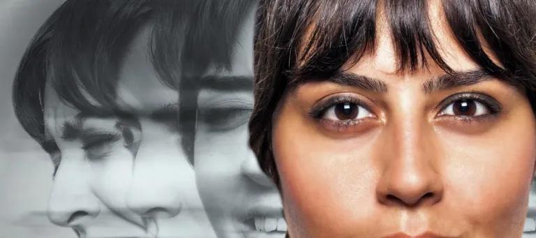 Woman looking at the camera with black and white images behind her