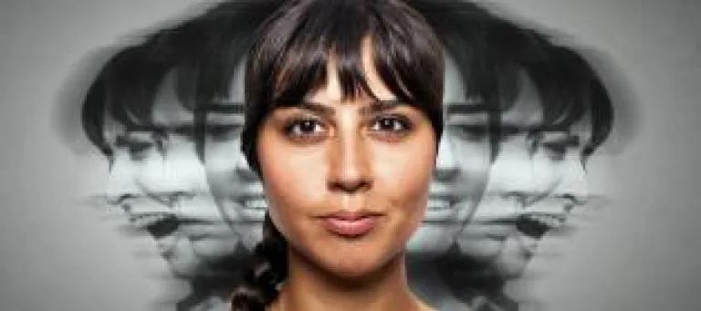 Woman looking at camera with black and white images of her face behind the main photo