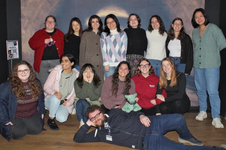 A group of students are smiling at the camera, having just succeeded at escaping an escape room together