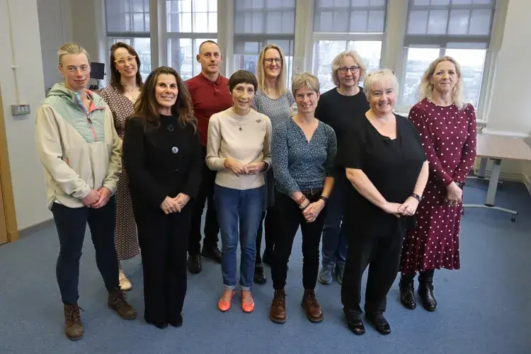 A group of current Nursing Studies lecturers stand together for a group photo, smiling at the camera.