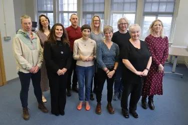 A group of current Nursing Studies lecturers stand together for a group photo, smiling at the camera.
