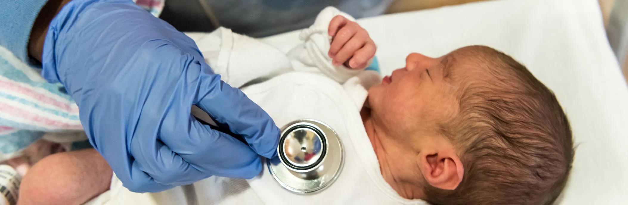 Newborn baby and stethoscope
