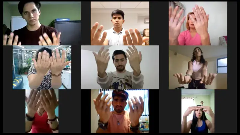 Participants of the Moving Through the Grieving Body hold their hands up, mid-movement, as part of choreography developed for bereavement support during this project.