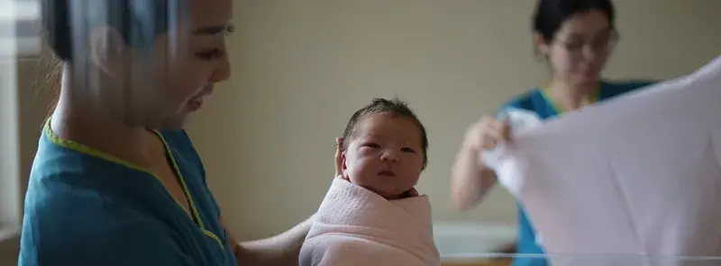 Two midwives in a hospital with a baby