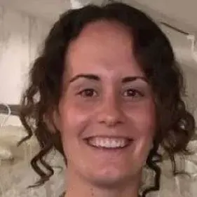 Sarah is smiling broadly at the camera