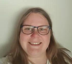 Catherine is smiling broadly at the camera in this headshot image