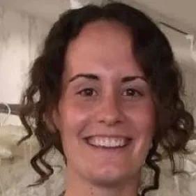 Sarah is smiling broadly at the camera